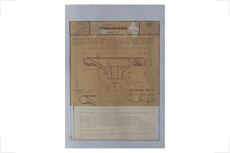 Überarbeitung eines Standards für Scheibenhandräder, Zeichnung, Studienarbeit 1964. Die bestehende TGL für Scheibenräder aus Formstoff TGL 621-51459.6785/8 der VEB Polygraph Leipzig war zu überarbeiten. Gewünscht wurde wegen der guten Griffigkeit ein Zweispeichenrad und eine Verbesserung der Gleitfähigkeit des Handrades bei schnellem selbstständigen Drehen des Rades in der Hand. Realisierung: Der Entwurf wurde angenommen und bildete die Grundlage des neuen Standards.