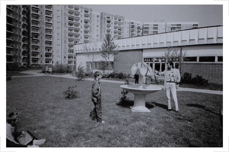 Brunnengestaltung für Rostock Groß Klein 1986 – 1989, Probeaufstellung des Modells am vorgesehenen Standort. Auftraggeber: Rat der Stadt Rostock Als Material konnte Stein, Metall oder Beton verwendet werden. Der Durchmesser des Wasserbeckens soll ungefähr 150cm betragen. Die Gestaltungskonzeption sah eine stilisierte Blume in Bronze und ein Wasserbecken aus grünem Travertin vor. Da der Auftrag für Bronzeguss und Natursteinschale von den angeschriebenen Auftragnehmern nicht bestätigt wurde, entschloss sich der Auftraggeber, einen Kupferschmied mit der Gesamtfertigung des Brunnens aus Kupfer zu beauftragen. Die Arbeiten verzögerten sich bis zur Währungsunion. Danach war eine Finanzierung der Arbeiten nicht mehr möglich.